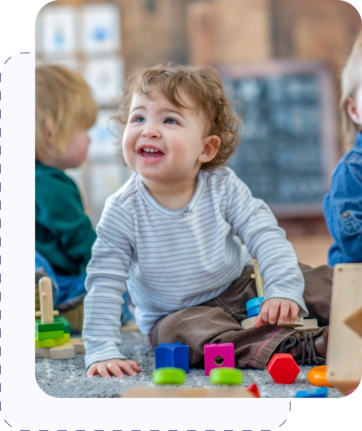 Toddler playing with colorful toys on floor.