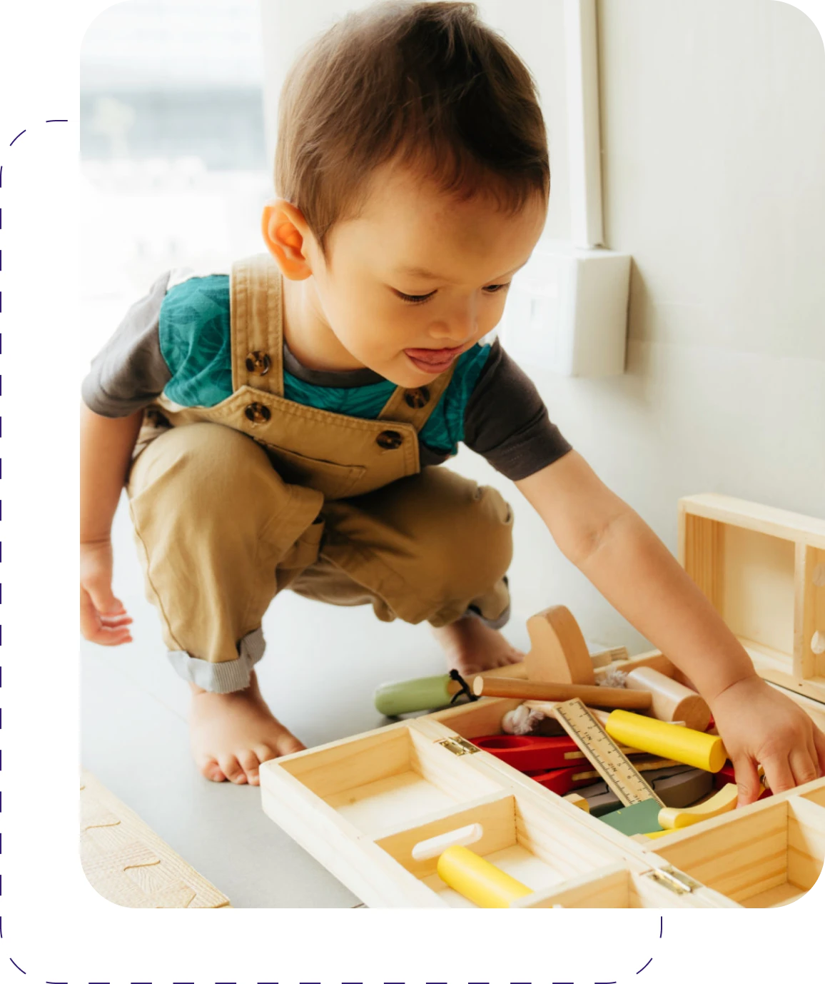 Child playing with wooden toy tools.