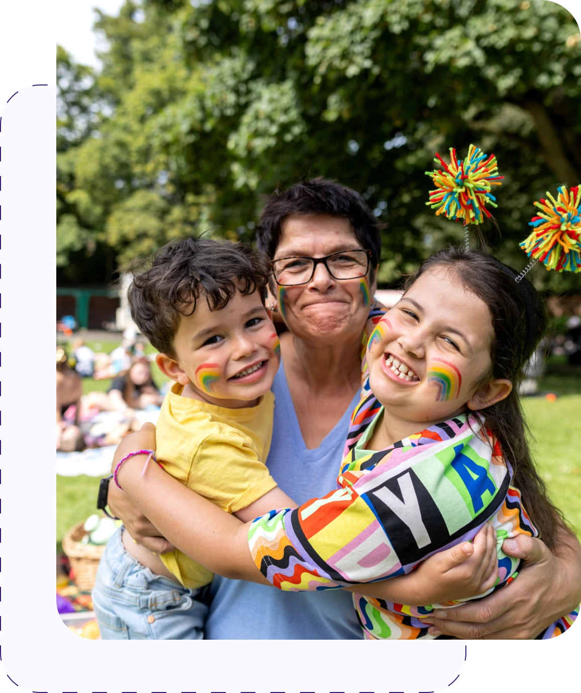Smiling group with rainbow face paint outdoors.